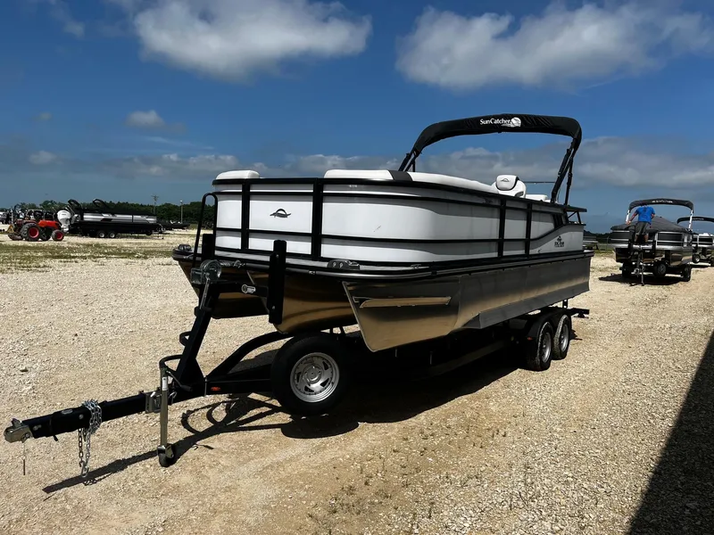 Slide: The Image of 2025 SunCatcher Select 322SS pontoon boat on trailer under clear blue sky. - 3