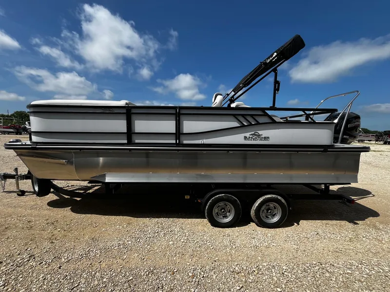Slide: The Image of 2025 SunCatcher Select 322SS pontoon boat on trailer under blue sky. - 4