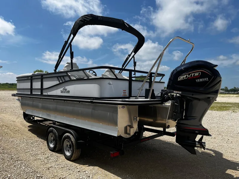 Slide: The Image of 2025 SunCatcher Select 322SS pontoon boat with Yamaha motor on a trailer, under blue sky. - 5