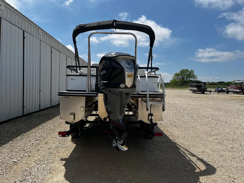 Slide: The Image of 2025 SunCatcher Select 322SS pontoon boat with outboard motor, parked outdoors. - 6