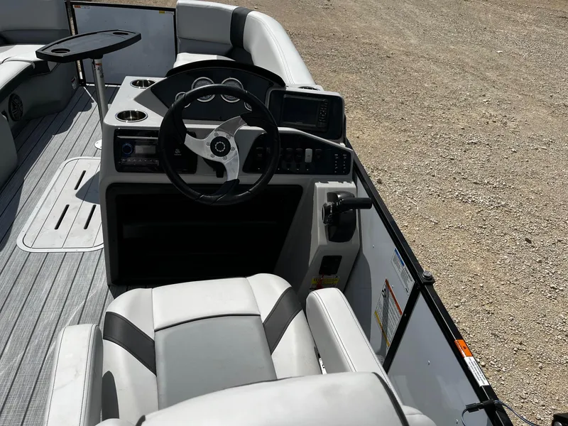 Slide: The Image of 2025 SunCatcher Select 322SS boat interior with steering wheel and seating. - 8