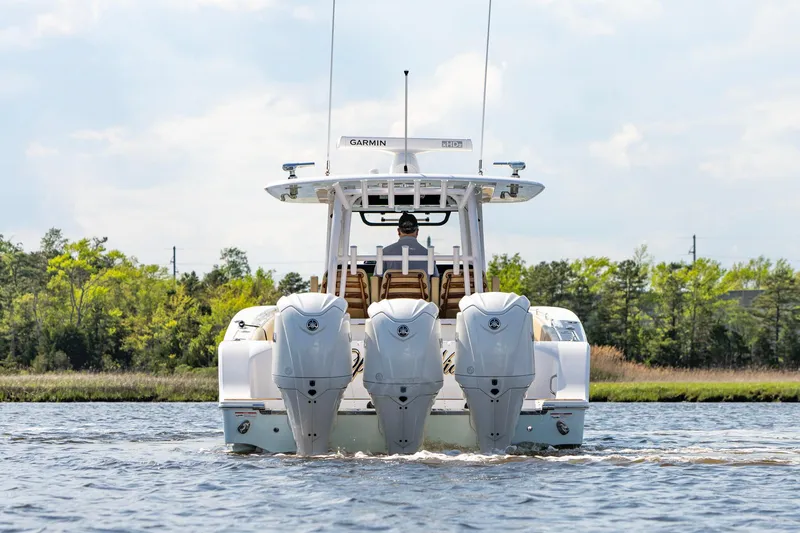 Slide: The Image of 2024 Sportsman Open 352 Center Console boat with triple engines on a calm waterway. - 11