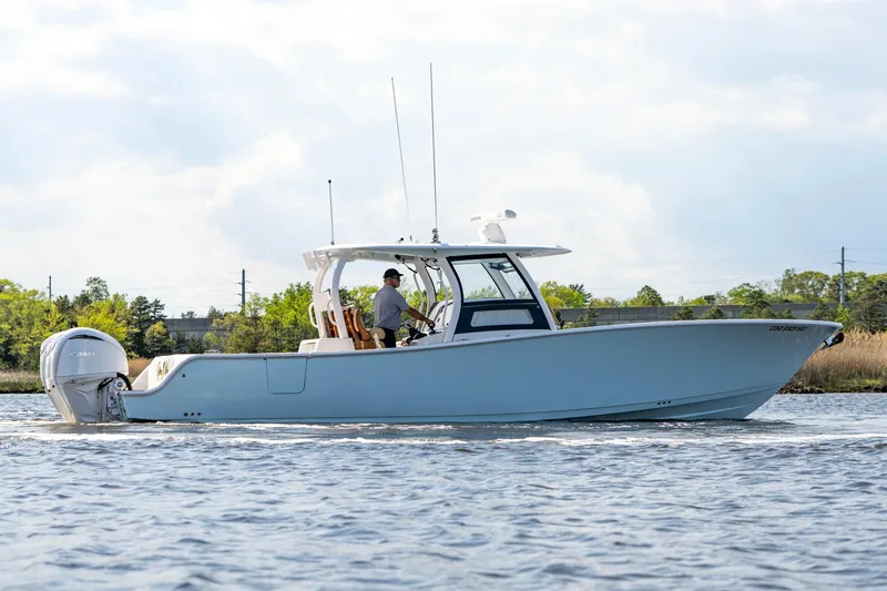Slide: The Image of 2024 Sportsman Open 352 Center Console boat cruising on a calm waterway. - 13