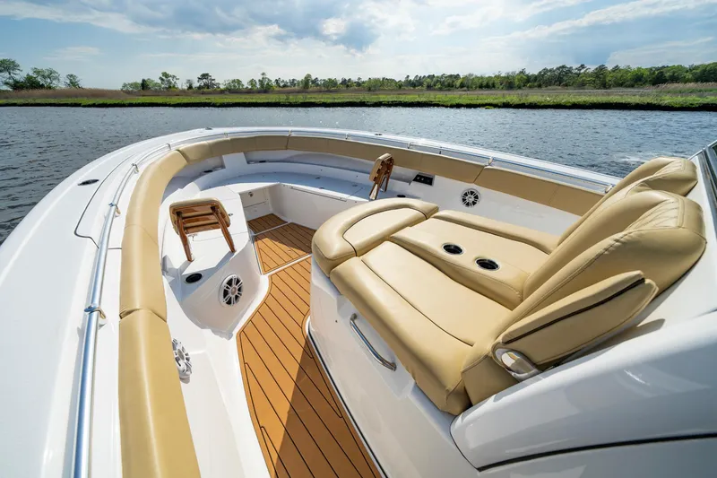 Slide: The Image of 2024 Sportsman Open 352 Center Console boat with tan seating on a calm river. - 15