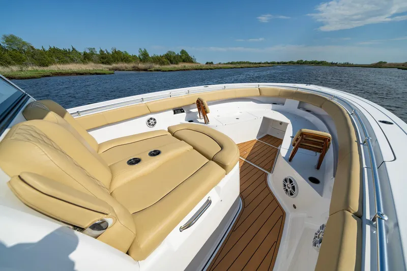 Slide: The Image of 2024 Sportsman Open 352 Center Console boat with tan seating, on a calm lake. - 16