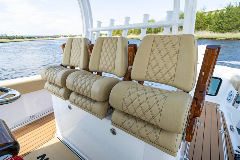 Slide: The Image of 2024 Sportsman Open 352 Center Console boat with luxurious tan seating and wooden accents. - 23