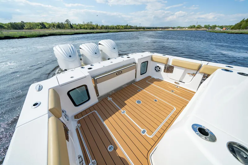 Slide: The Image of 2024 Sportsman Open 352 Center Console boat with triple engines on a sunny day. - 26