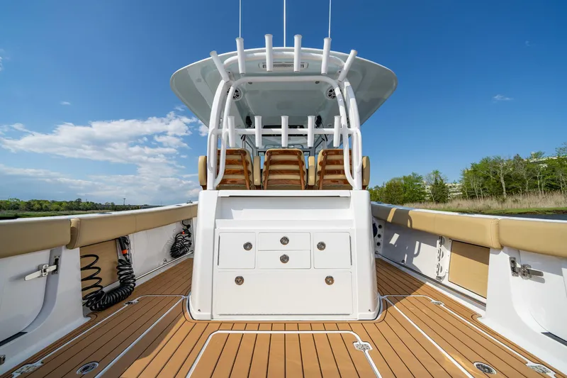 Slide: The Image of 2024 Sportsman Open 352 Center Console boat with sleek deck and seating under clear blue sky. - 27