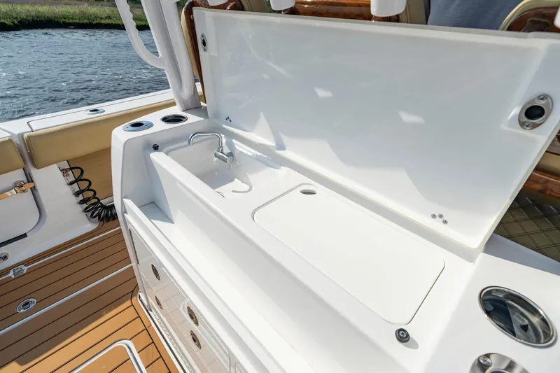 Slide: The Image of 2024 Sportsman Open 352 Center Console boat with sleek white sink and storage area. - 28