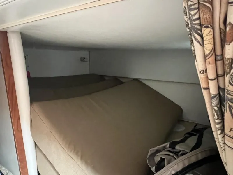 Slide: The Image of Interior cabin of 2004 Four Winns 248 Vista boat with beige cushions and patterned curtain. - 20