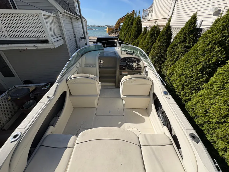 Slide: The Image of 2007 Sea Ray 215 Weekender boat with spacious seating, docked near waterfront homes. - 10