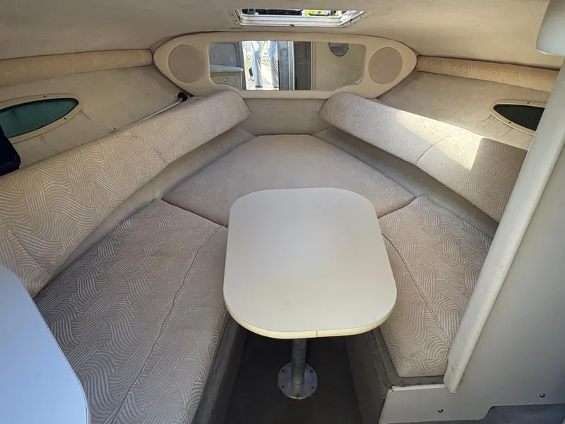 Slide: The Image of 2007 Sea Ray 215 Weekender cabin interior with beige seating and table. - 17