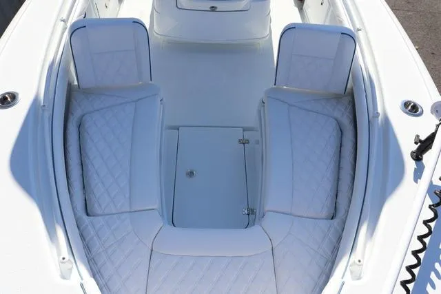 Slide: The Image of 2025 Yellowfin 26 Hybrid boat interior with white cushioned seating and storage compartments. - 7
