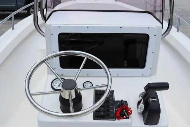 Slide: The Image of 2023 May-Craft 1900 CC boat console with steering wheel and controls. - 20