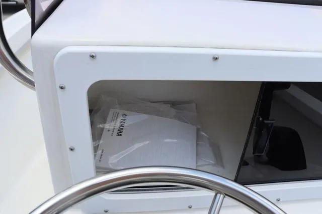Slide: The Image of 2023 May-Craft 1900 CC boat console storage with Yamaha manual inside. - 22
