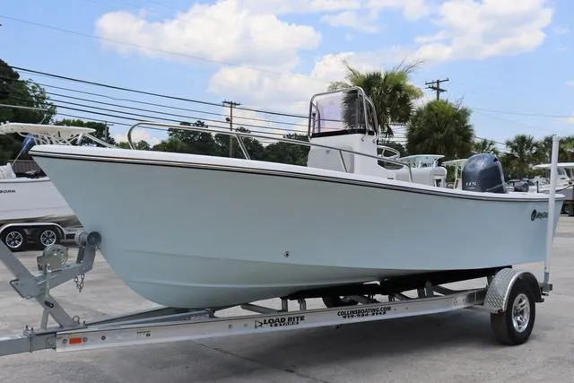 Slide: The Image of 2023 May-Craft 1900 CC boat on trailer, parked outdoors under a partly cloudy sky. - 6