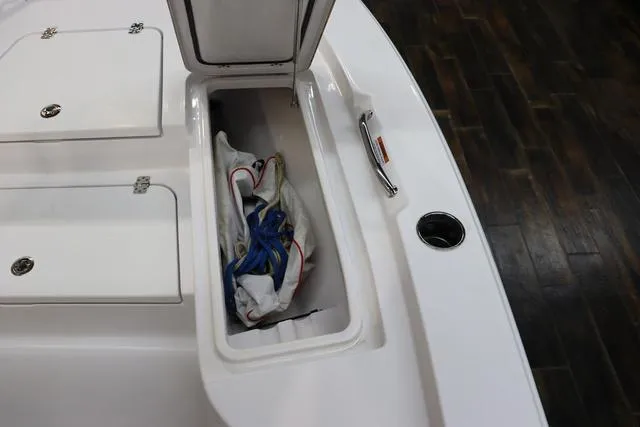 Slide: The Image of 2021 Sportsman Masters 207 Bay Boat storage compartment with open hatch and gear inside. - 12