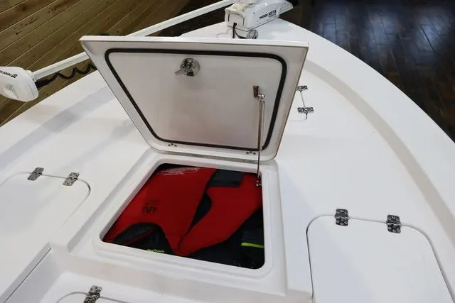 Slide: The Image of Open storage compartment on 2021 Sportsman Masters 207 Bay Boat with life jacket inside. - 13