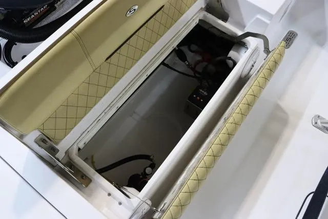 Slide: The Image of 2021 Sportsman Masters 207 Bay Boat storage compartment with cushioned seating and electrical components. - 7
