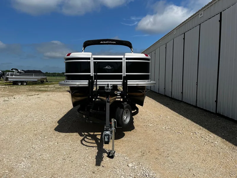 Slide: The Image of 2025 SunCatcher Select 324RC pontoon boat on trailer, parked outdoors. - 2