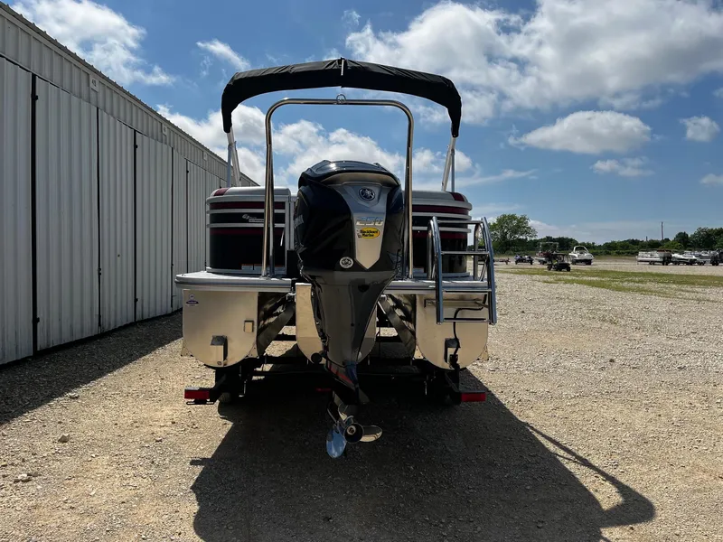 Slide: The Image of 2025 SunCatcher Select 324RC pontoon boat with outboard motor, parked outdoors. - 6