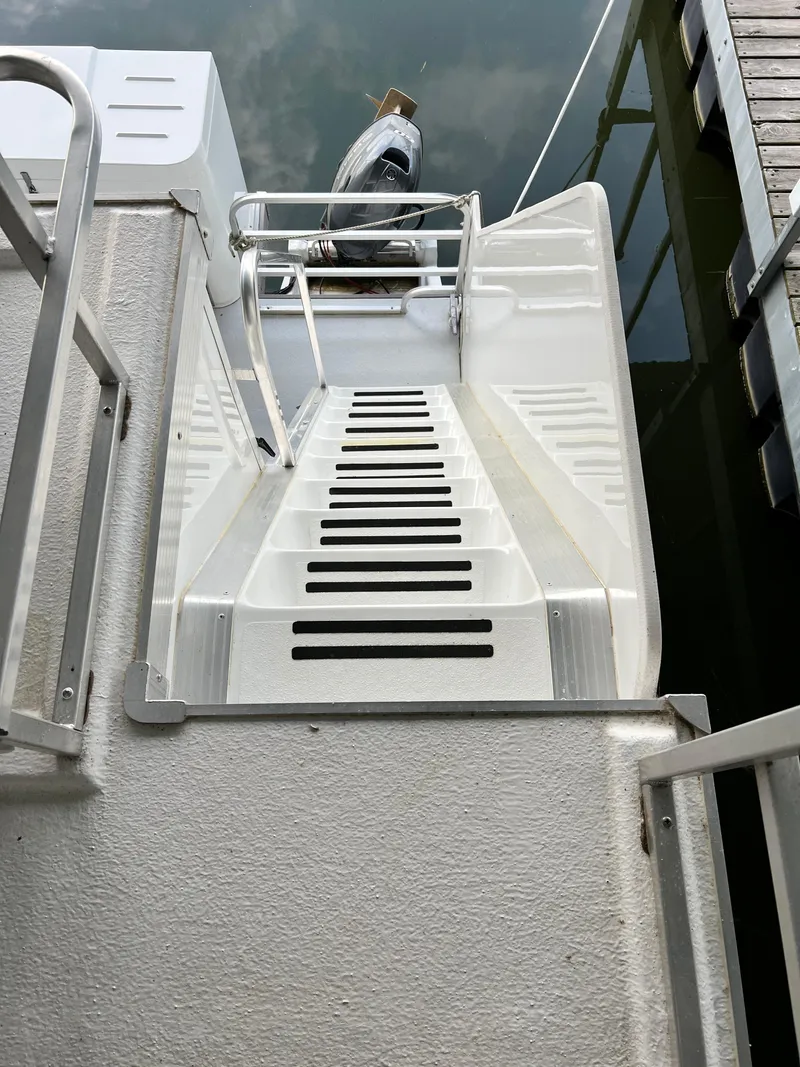 Slide: The Image of Stern view of 2021 Catamaran Cruisers 39 x 12 Houseboat with ladder and railing. - 13