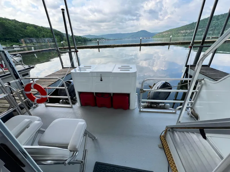 Slide: The Image of 2021 Catamaran Cruisers houseboat deck with scenic lake and mountain view. - 14