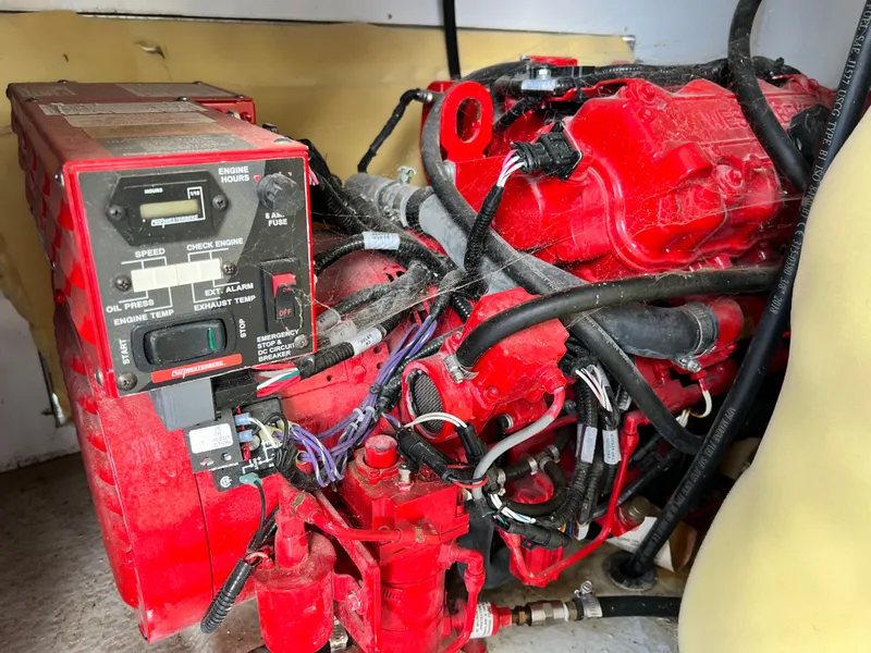 Slide: The Image of Red engine of a 2021 Catamaran Cruisers 39 x 12 Houseboat, featuring control panel and wiring. - 16