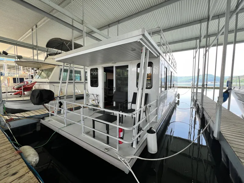 Slide: The Image of 2021 Catamaran Cruisers 39 x 12 Houseboat docked in a marina under a covered structure. - 22