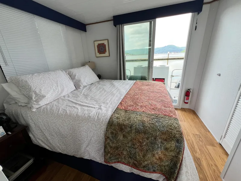 Slide: The Image of Cozy bedroom in 2021 Catamaran Cruisers houseboat with lake view and sliding glass door. - 9