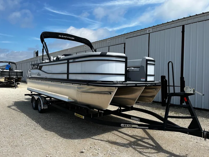 Slide: The Image of 2025 SunCatcher Select 324SS pontoon boat on trailer, parked outdoors. - 1