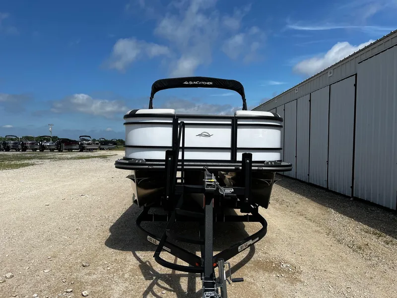 Slide: The Image of 2025 SunCatcher Select 324SS pontoon boat on trailer, parked outdoors. - 2
