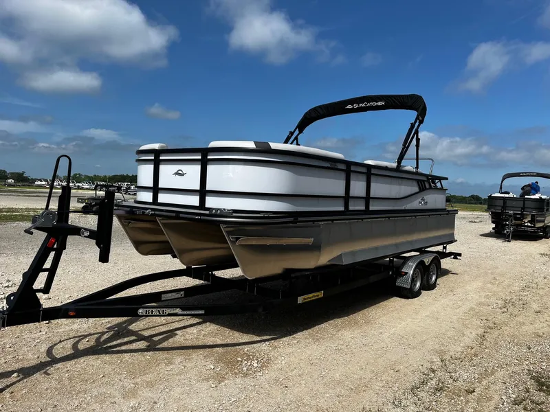Slide: The Image of 2025 SunCatcher Select 324SS pontoon boat on trailer under blue sky. - 3