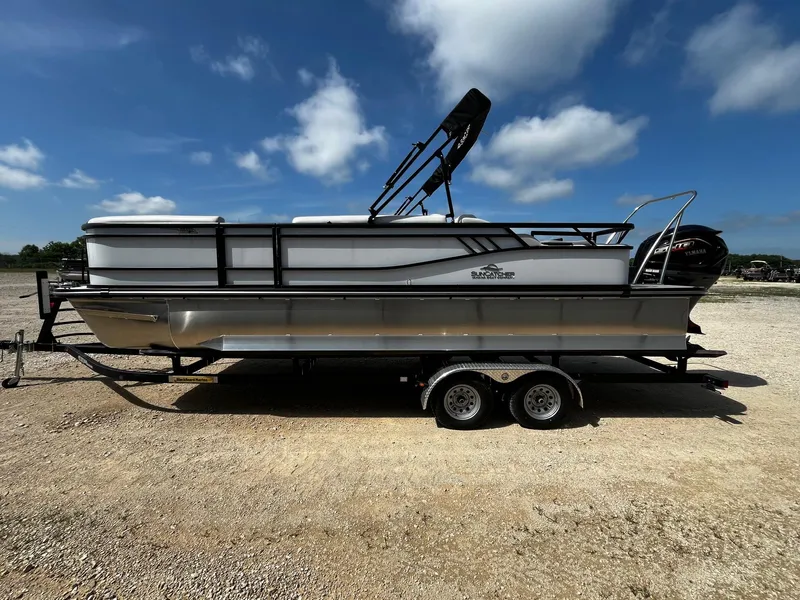 Slide: The Image of 2025 SunCatcher Select 324SS pontoon boat on trailer under blue sky. - 4
