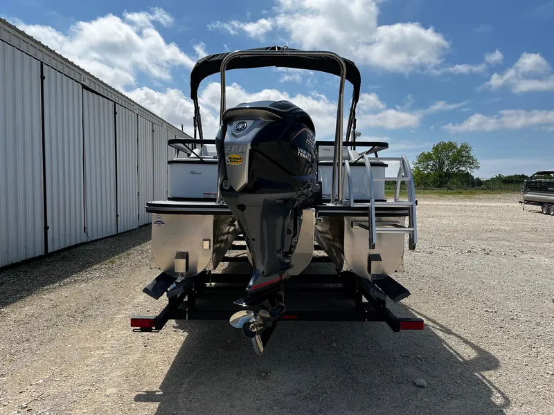 Slide: The Image of 2025 SunCatcher Select 324SS pontoon boat with outboard motor on trailer, parked outdoors. - 6
