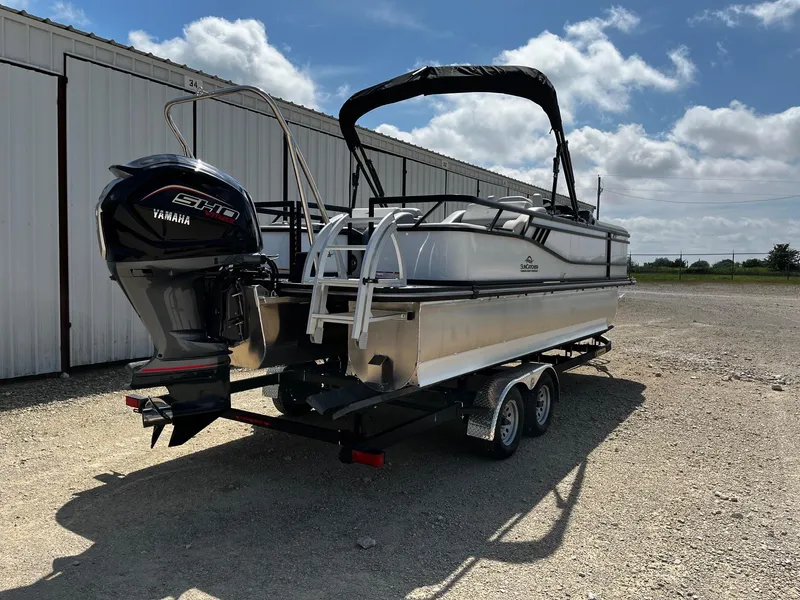 Slide: The Image of 2025 SunCatcher Select 324SS pontoon boat on trailer, featuring Yamaha engine, parked outdoors. - 7