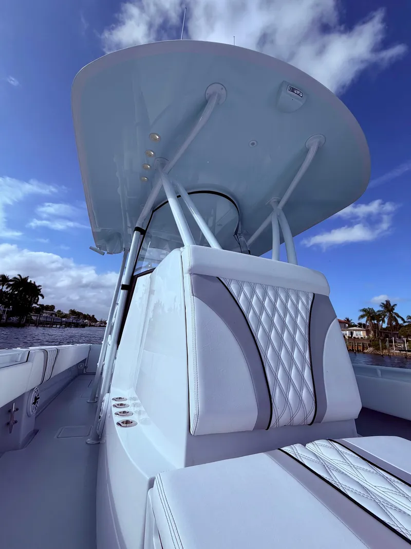 Slide: The Image of 2024 Contender 39 ST boat with sleek design and luxurious seating under a clear blue sky. - 10