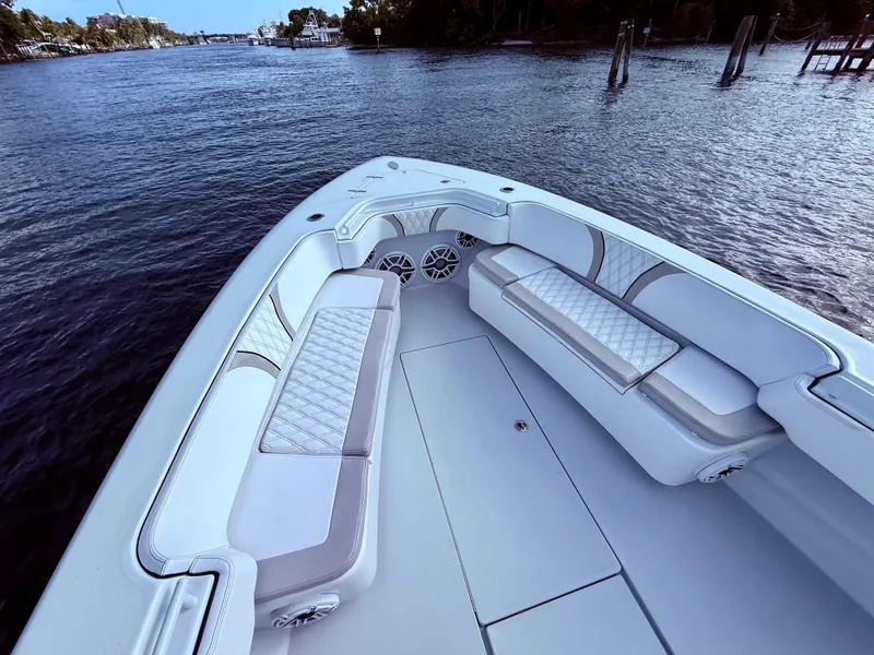 Slide: The Image of 2024 Contender 39 ST boat interior with luxurious seating on a calm waterway. - 11