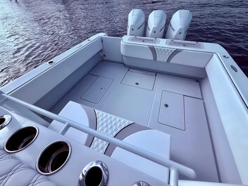 Slide: The Image of 2024 Contender 39 ST boat with triple engines, spacious deck, and sleek design on the water. - 17