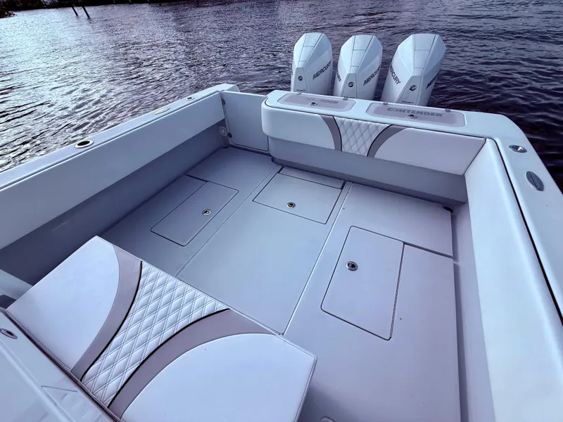 Slide: The Image of 2024 Contender 39 ST boat with spacious deck and triple outboard engines on water. - 18