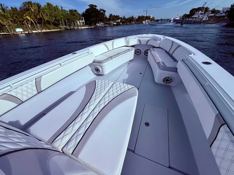 Slide: The Image of 2024 Contender 39 ST boat interior with luxurious seating on a calm waterway. - 25