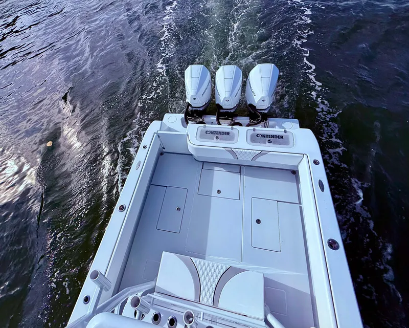 Slide: The Image of 2024 Contender 39 ST boat with triple engines cruising on water. - 31