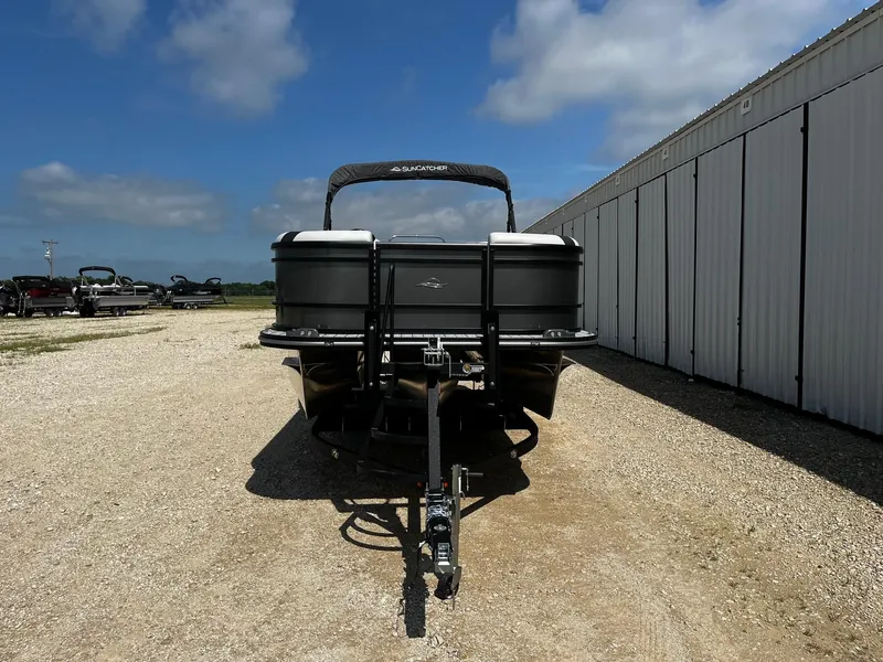 Slide: The Image of 2025 SunCatcher Select 322RC boat on trailer, parked outdoors under a blue sky. - 2