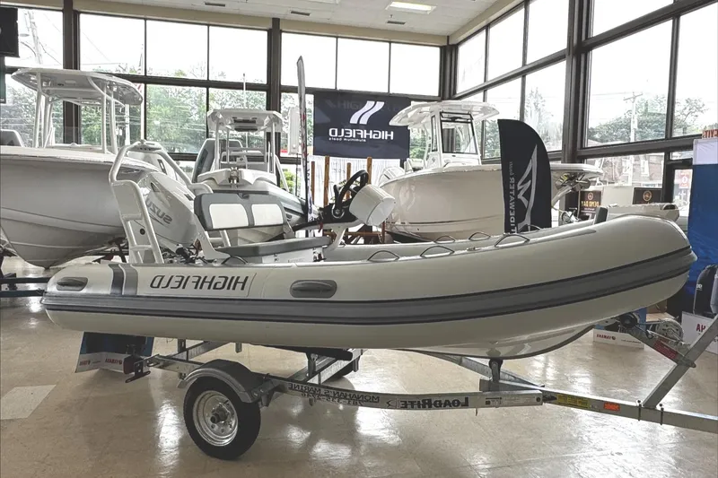 Slide: The Image of 2025 Highfield CL400 inflatable boat displayed indoors on a trailer. - 0