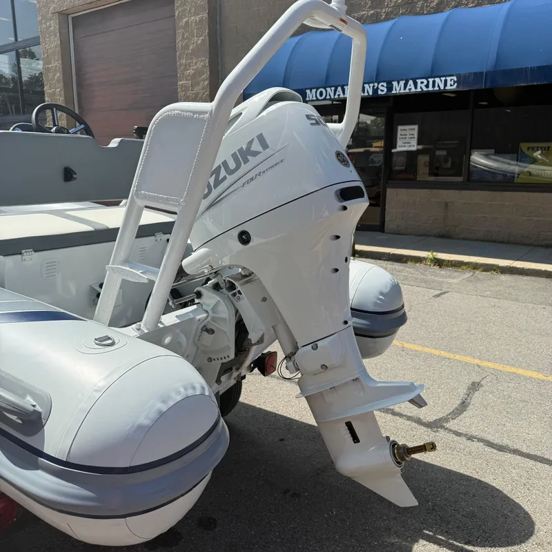 Slide: The Image of Highfield CL400 boat with Suzuki outboard motor, parked outside Monahan's Marine. - 4