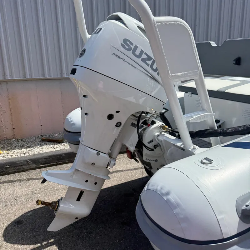 Slide: The Image of 2025 Highfield CL400 boat with Suzuki outboard motor, parked outdoors. - 5