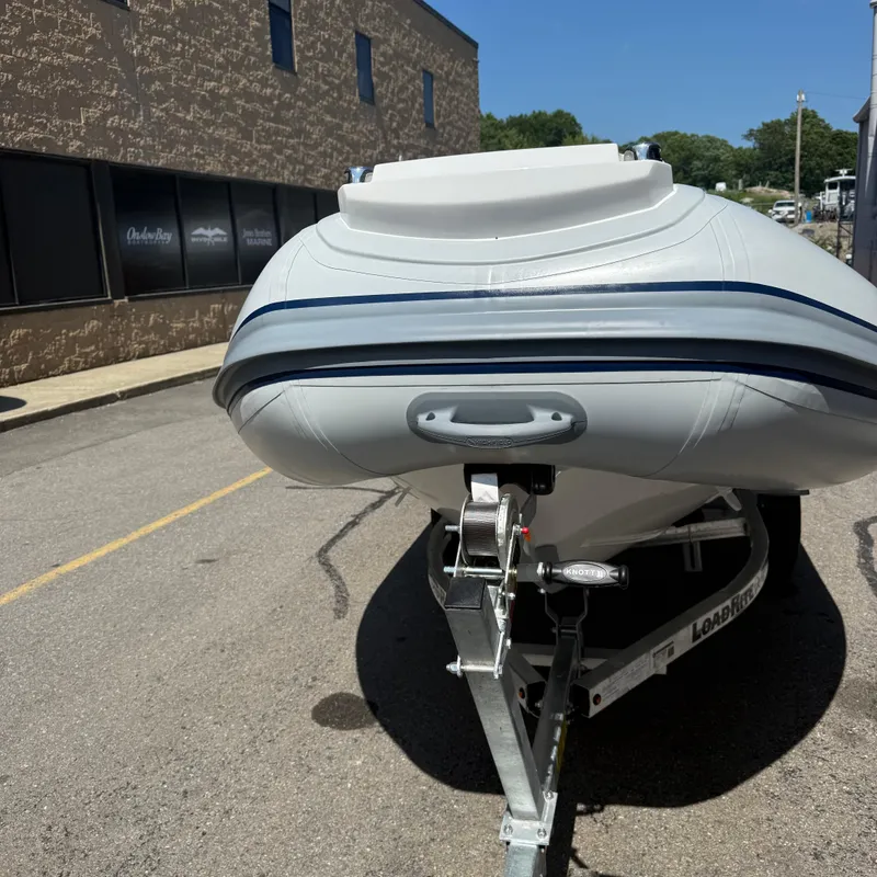Slide: The Image of 2025 Highfield CL400 boat on trailer, parked outdoors near a building. - 6