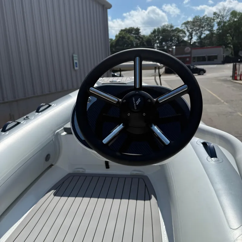 Slide: The Image of Steering wheel of 2025 Highfield CL400 boat, docked outdoors under a sunny sky. - 7