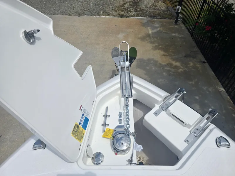 Slide: The Image of 2025 Pursuit S 248 Sport boat anchor compartment with open hatch and anchor chain. - 11