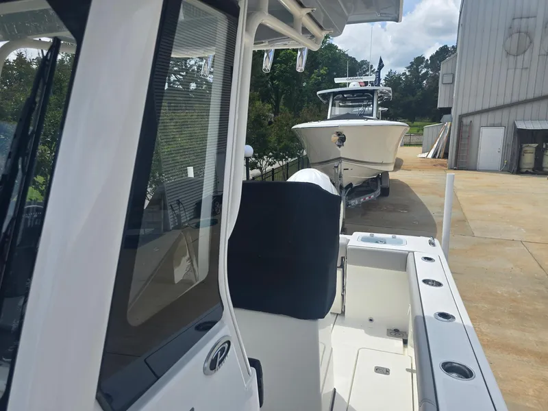 Slide: The Image of 2025 Pursuit S 248 Sport boat parked outdoors near a building. - 12